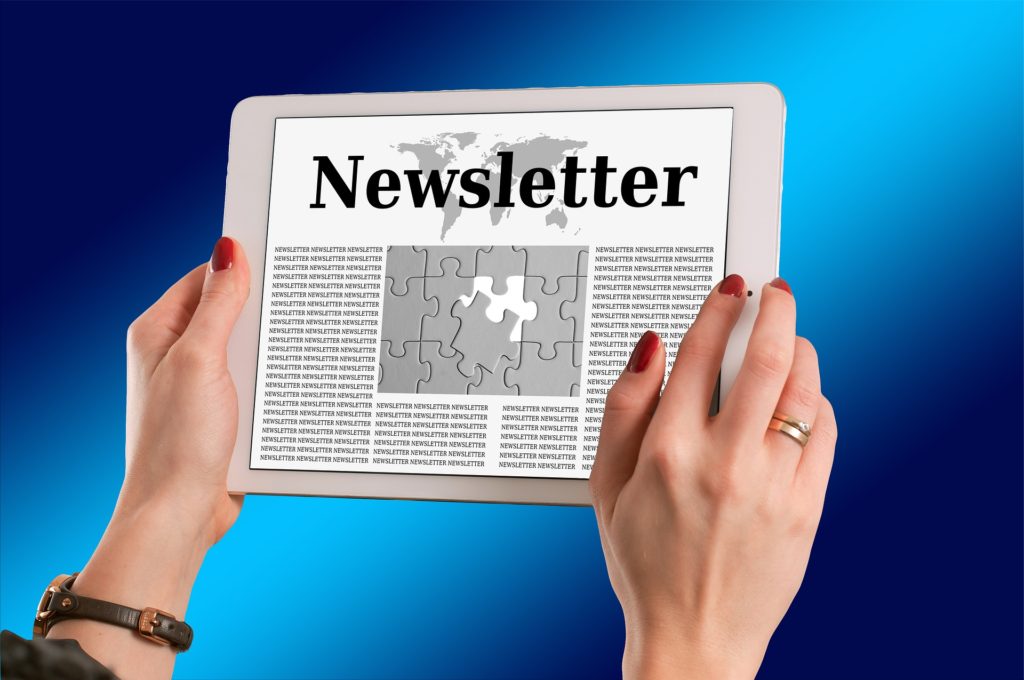 Woman holding tablet with headline saying Newsletter