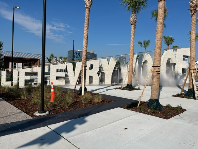 Lift Ev'ry Voice and Sing Park. The words "Lift Ev'ry Voice" is large block concrete are visible with palm trees in the foreground.