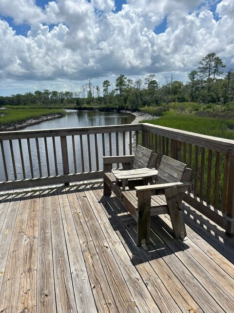 Wooden chairs on the bridge overlooking the Clapboard Creek.